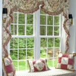 Custom window seat framed with swags and cascades, window seat cushion and decorative pillows